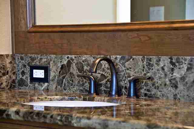Photo of Brown Colored Granite Backsplash and Countertop on a Residential Bathroom Sink After Professional Granite Cleaning and Sealing Bay Shore Cleaning & Restoration